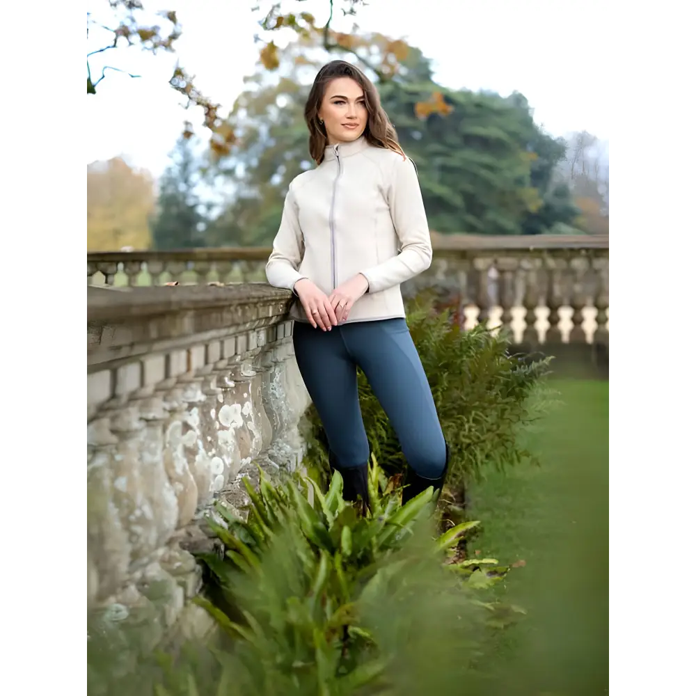 Young woman in Lemieux Faye Fleece Zip Through Stone next to ornate balustrade