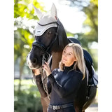 Black horse wearing lemieux finesse acoustic white mesh acoustic fly hood stone for fly protection