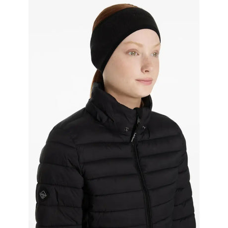 Black puffer jacket with horizontal stitching and a lemieux fleece earwarmer black logo patch on the sleeve