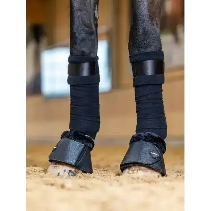Black leather lemieux fleece wrapround overreach boots with plush fleece lining and adjustable straps for protection