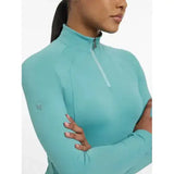 A teal lemieux halle lightweight base layer lagoon with long sleeves, high collar, and zipper detail for athletic wear