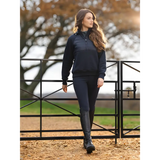 Woman in navy blue outfit showcasing the Lemieux Harley Hybrid Hoodie walking by a fence