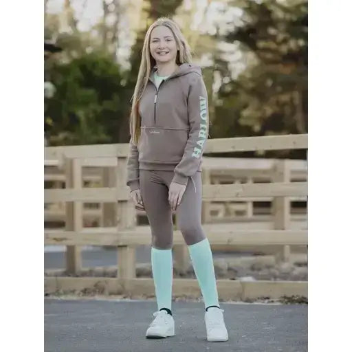 Brown zip-up hoodie with harlow lettering down the sleeve paired with lemieux harlow competition socks dusty cora