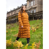 Woman outdoors in a Lemieux Harper Longline Puffer Coat Ginger in mustard yellow