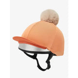 Orangish-pink lemieux hat silk sherbet cover with fluffy beige pom-pom and silver reflective trim, silky smooth 4-way fabric