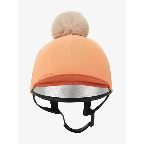 Peach colored lemieux hat silk equestrian helmet cover with fluffy beige pom pom and silver reflective band silky smooth 4 way