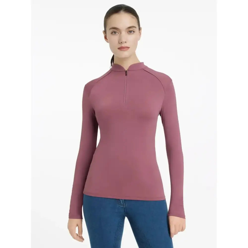A sleek mauve lemieux heyden lightweight base layer rosewood with long sleeves and a quarter-zip neckline seamless design
