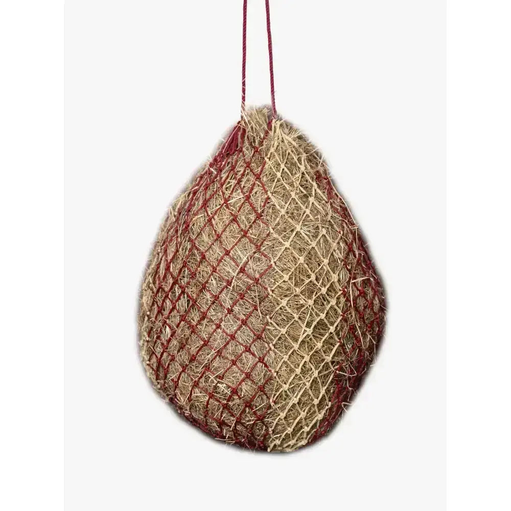 A hanging lemieux hippo hay net burgundy and beige mesh feeder filled with straw for easy hay feeding