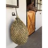 A hanging round lemieux hippo haynet rosemary filled with green and brown grasses perfect for greedy feeders