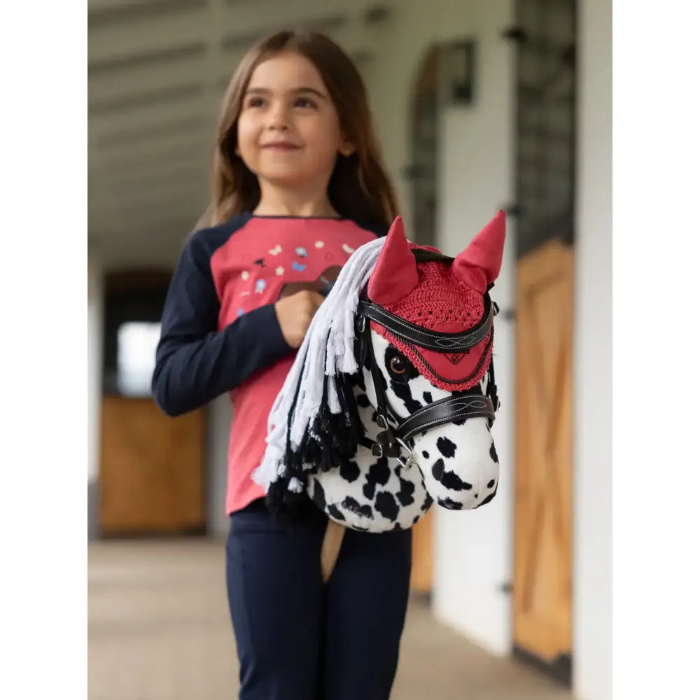 A plush dapple gray lemieux hobby horse head wearing a red lace fly hood cranberry with black leather straps