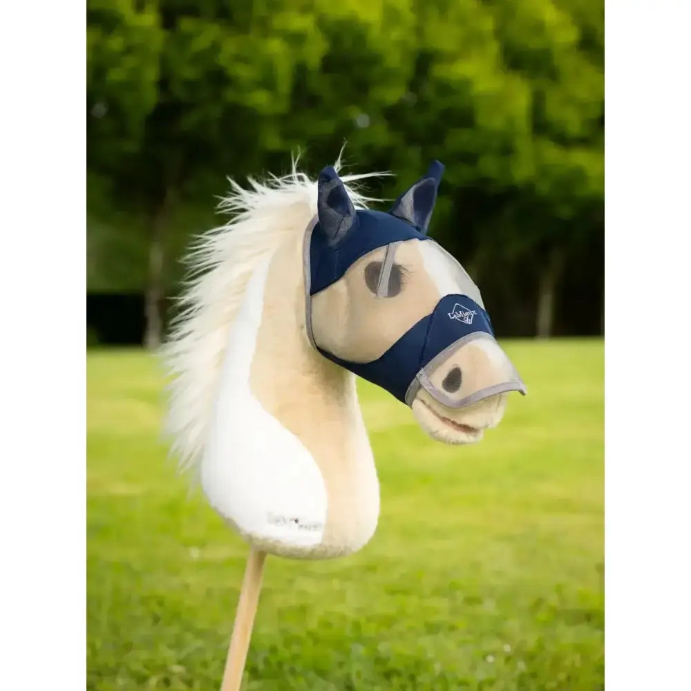 A cream lemieux hobby horse with a white mane wearing a navy blue hobby horse fly mask for protection