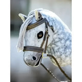 A lemieux hobby horse hunter bridle on a plush white and gray dapple horse head with brown leather straps
