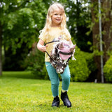 A lemieux hobby horse montana backpack shaped like a horse with pink and black cow print and a textured surface