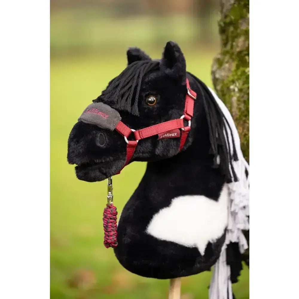 Black and white plush lemieux hobby horse razzle with red harness and braided pink tassel for kids play fun