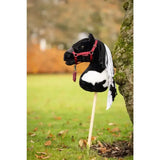 Black and white plush lemieux hobby horse razzle with red bridle on wooden stick for kids play and riding fun