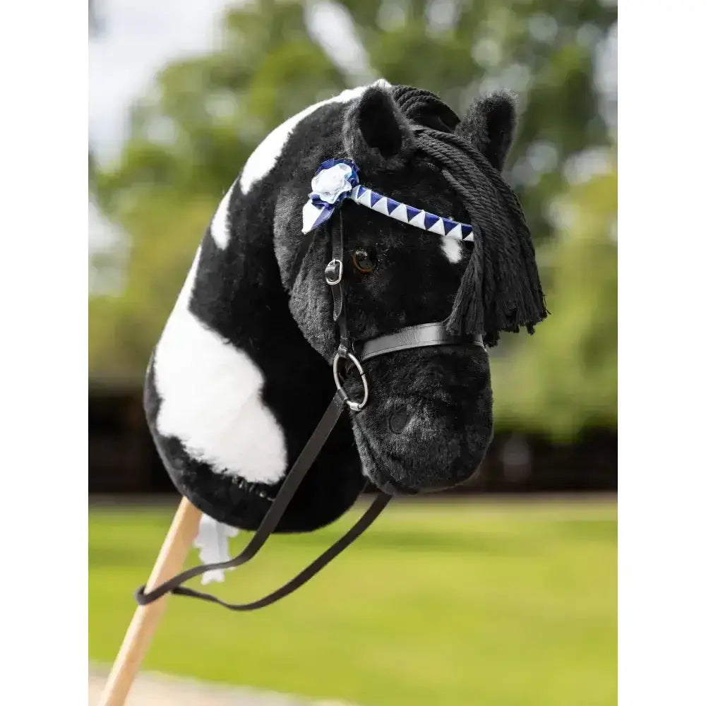 Black and white lemieux hobby horse head with blue triangular showing bridle and black leather straps with bow