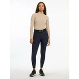 Beige high neck long sleeve riding top with subtle side panel detailing paired with lemieux isabelle seat breeches navy featuring tonal reflective details