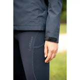 Dark gray form-fitting equestrian leggings with lemieux logo and black cuff paired with lemieux isla short waterproof jacket navy