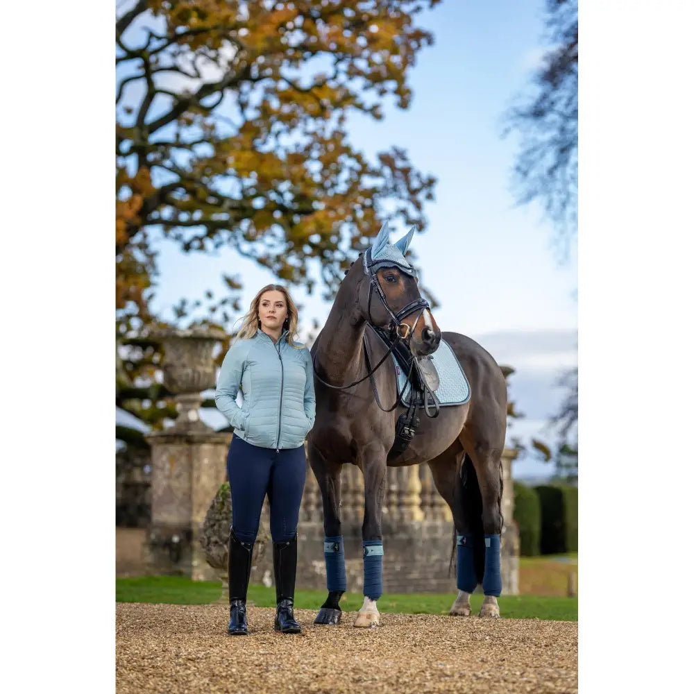 Horse standing next to a person wearing Lemieux Juliette Jacket Glacier outdoors