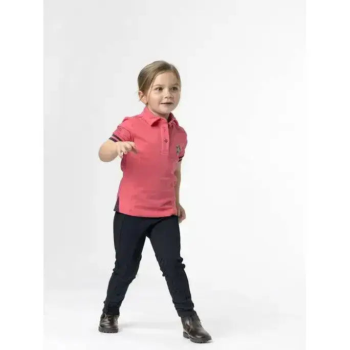 A child wearing lemieux junior pro breeches black with tapered lower leg paired with a pink polo shirt