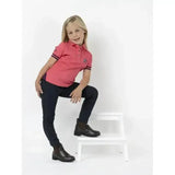 Pink polo shirt with dark trim and small star detail shown with lemieux junior pro breeches black tapered lower leg