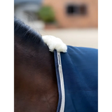 Horse’s neck in Lemieux Kudos Stable Rug 50g Navy with blue blanket and white trim