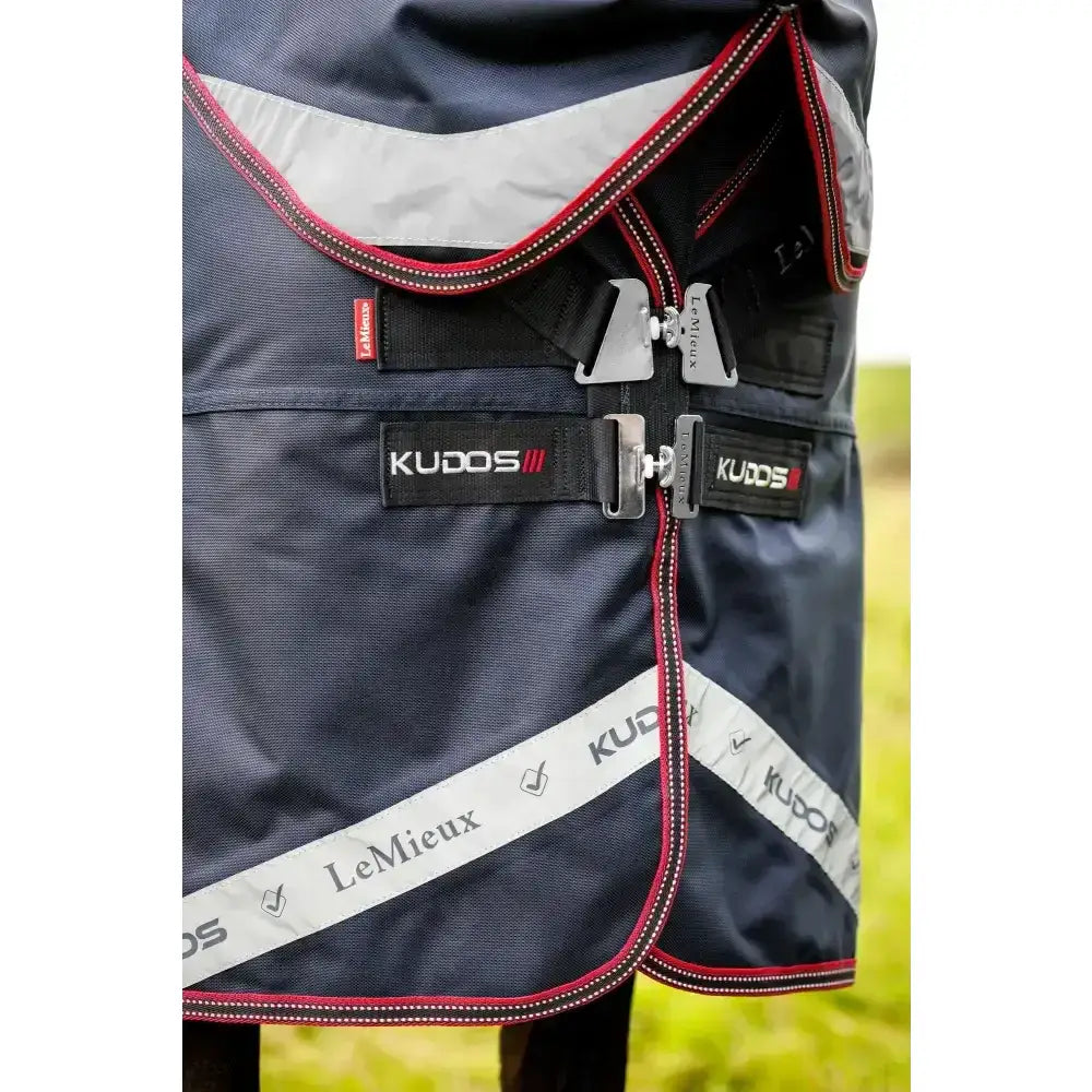 Dark navy lemieux kudos thermo layer turnout rug 300g with red silver trim black straps and reflective stripe on side