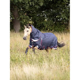 Horse in navy blue Lemieux Kudos Turnout Rug 50g running in grassy field