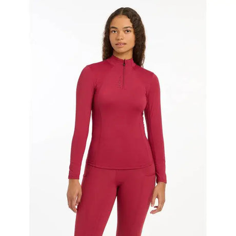 Woman in red quarter-zip Lemieux Ladies Base Layer Ember athletic top