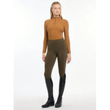 Woman in Lemieux Ladies Base Layer Ginger with mustard turtleneck and olive riding pants