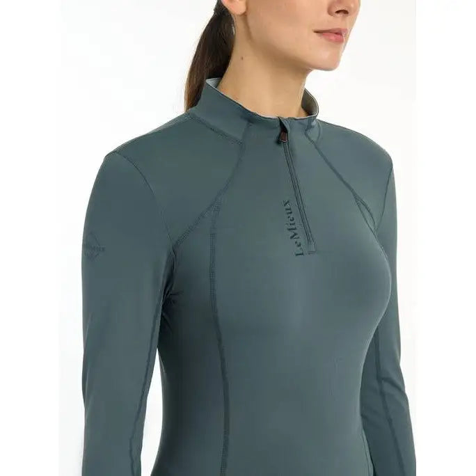 Teal long-sleeved athletic top featuring a quarter-zip collar, Lemieux Ladies Base Layer Petrol