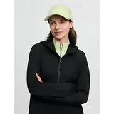 Black zip-up hoodie with subtle textured fabric and matching hood worn over light green layer lara cap macaron