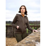 Woman in Lemieux Leia Lined Hoodie Alpine beside a rustic stone wall