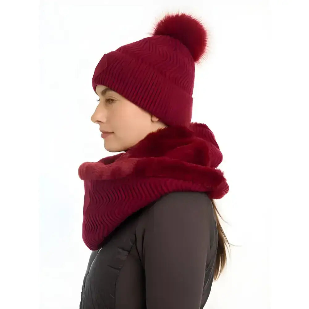 A rich burgundy lemieux lila snood ember beanie and matching faux fur-lined scarf with chevron knit pattern