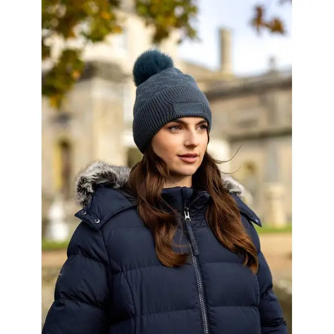 Woman in navy blue puffer jacket, gray knit hat, wearing Lemieux LM Beanie Petrol