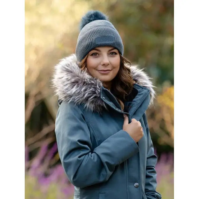 Woman in blue winter coat and gray knit hat with Lemieux LM Beanie Petrol featuring faux fur