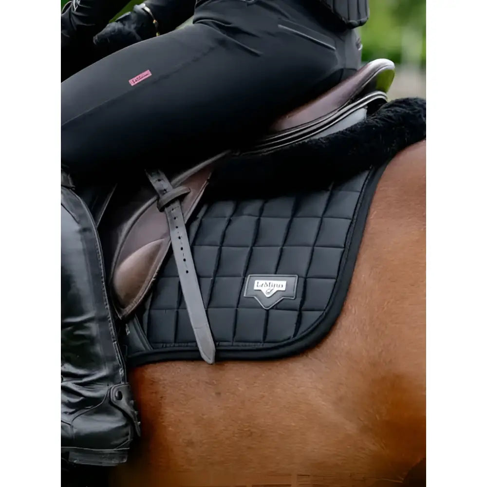 Black quilted saddle pad with silver logo patch and leather straps for lemieux loire classic close contact use