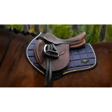 Navy blue quilted lemieux loire classic saddle pad with gold trim and black leather saddle for classic close contact use