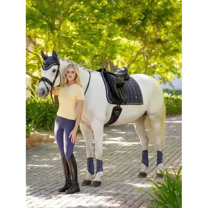 White horse wearing lemieux loire classic dressage square dusk blue with black saddle and blue leg wraps