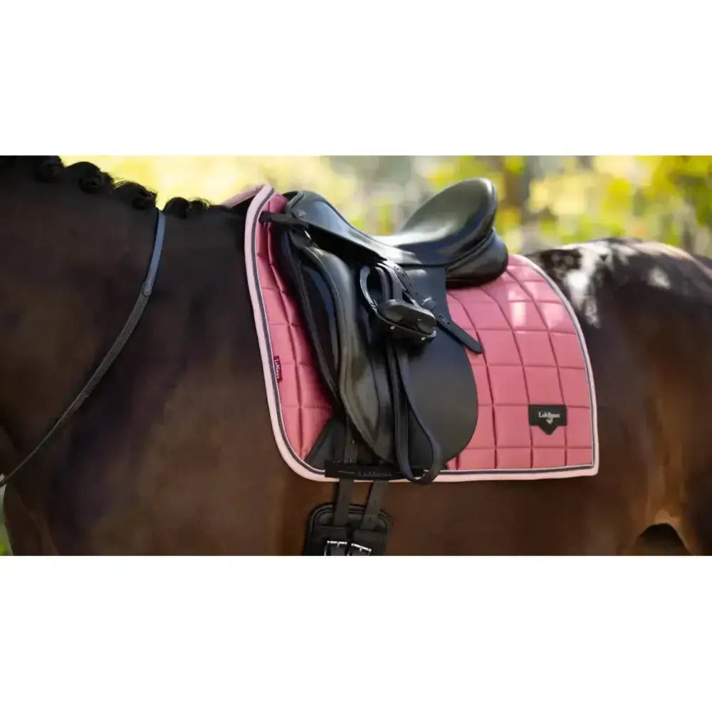 Pink quilted lemieux loire classic dressage square peony saddle pad with white trim and black brand logo
