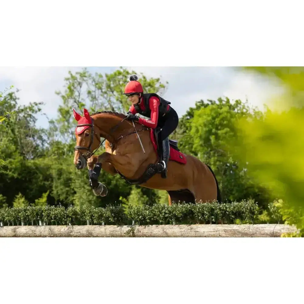 Red lemieux loire close equestrian helmet with a small black pom-pom perfect for contact square chilli use