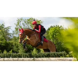 Red lemieux loire close equestrian helmet with a small black pom-pom perfect for contact square chilli use