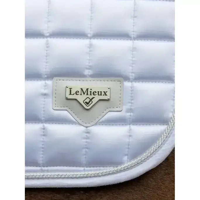 White quilted lemieux loire close contact square saddle pad with stitched brand label for close contact riding