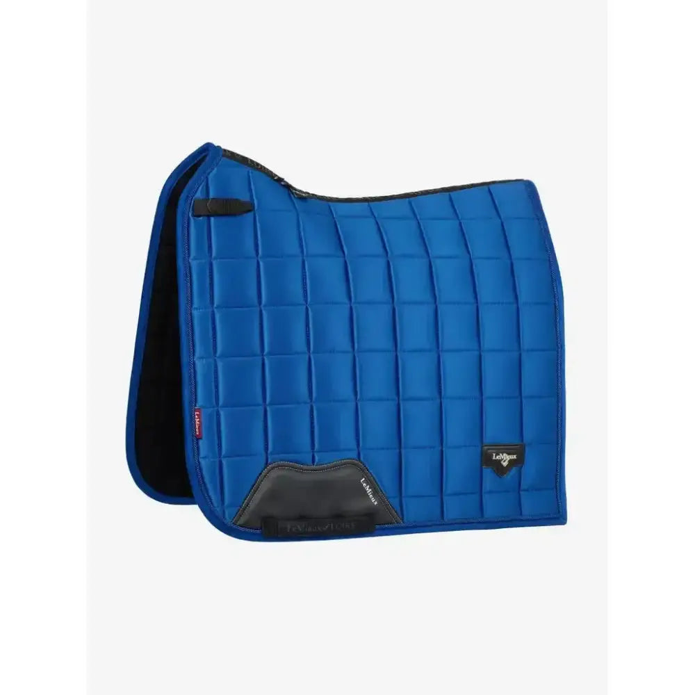 Bright blue quilted lemieux loire dressage square saddle pad with black trim and branded logo patch