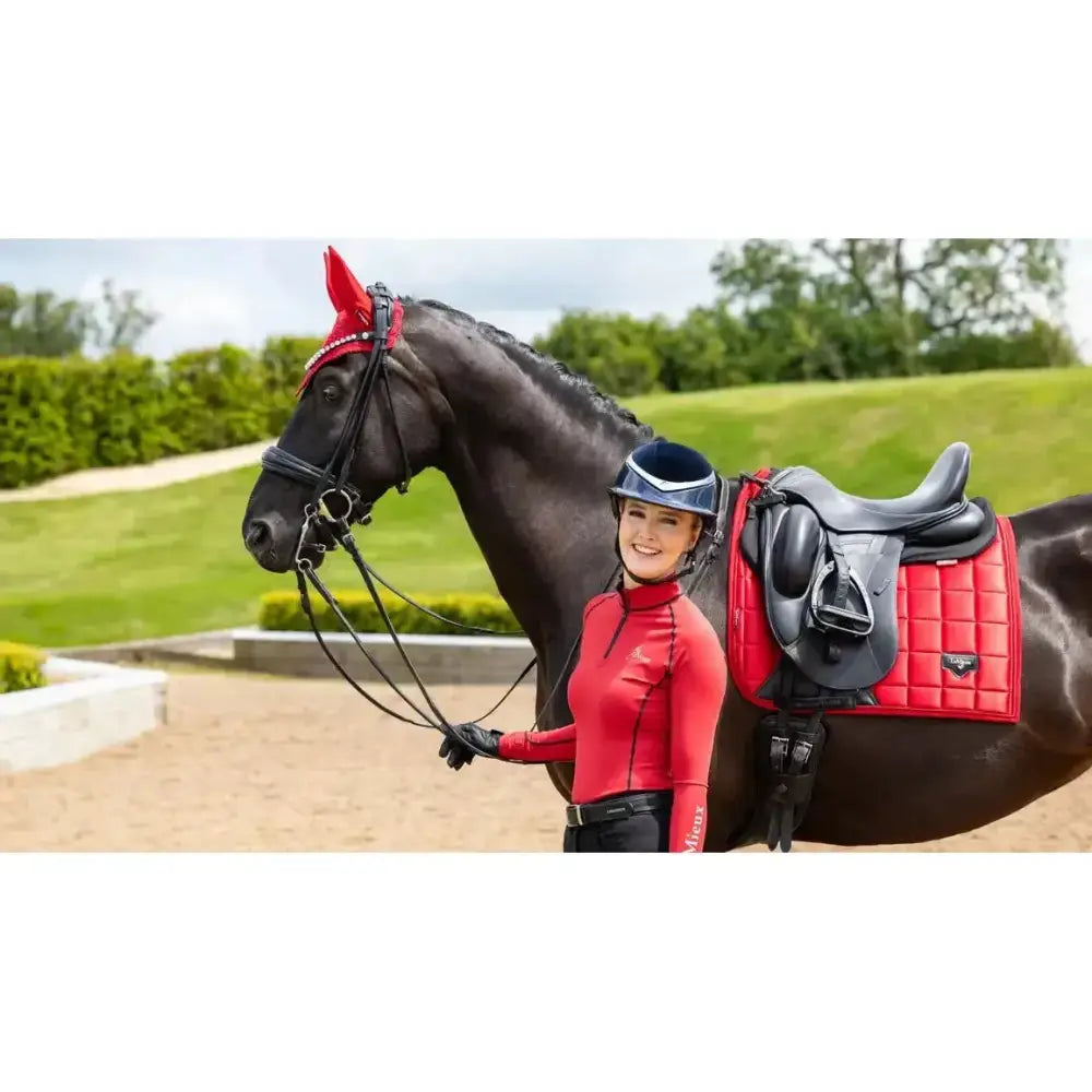 Red quilted lemieux loire dressage square chilli pad with black leather stirrups and matching ear cover