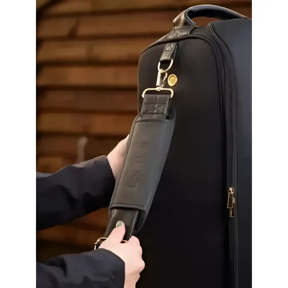 Black leather shoulder strap with gold hardware and embossed branding on lemieux luxe boot bag black