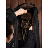 Black lemieux luxe bridle bag made of faux leather with padded interior holding brown leather horse bridle and headpiece