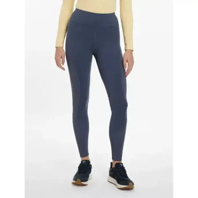 Dark blue lemieux lydia mesh leggings made of stretchy fabric paired with beige top and black sneakers