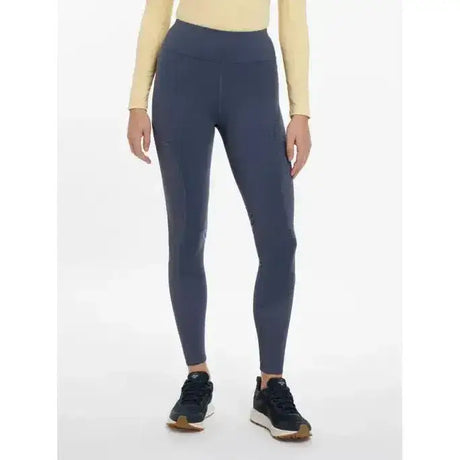 Dark blue lemieux lydia mesh leggings made of stretchy fabric paired with beige top and black sneakers