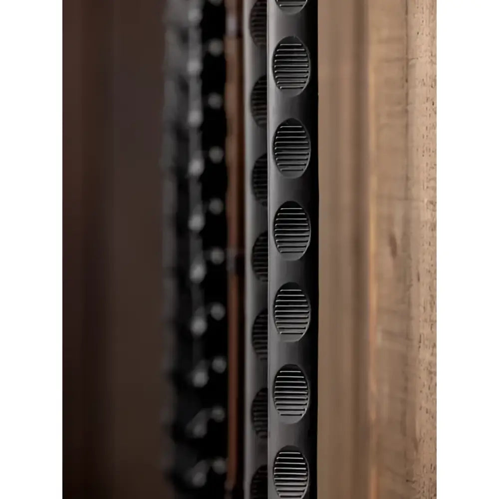 Black perforated metal wine rack with circular slotted design paired with lemieux magna grip rubber reins black silver
